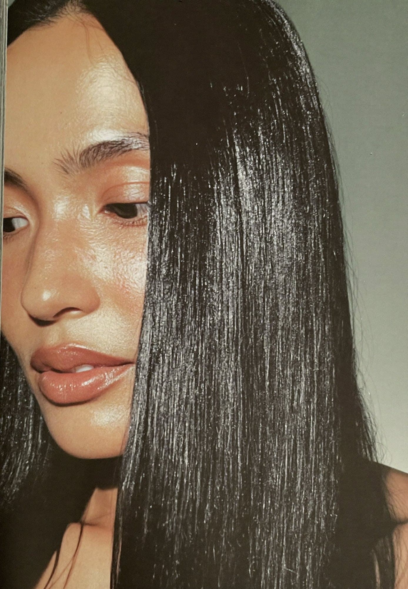 A close crop of glossy jet-black hair falling across a woman's face.